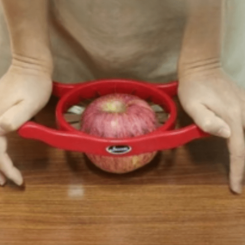 coupe legumes personne appuyant pour couper une pomme