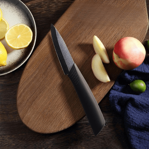 couteau ceramique psé sur une planche avec un fruit