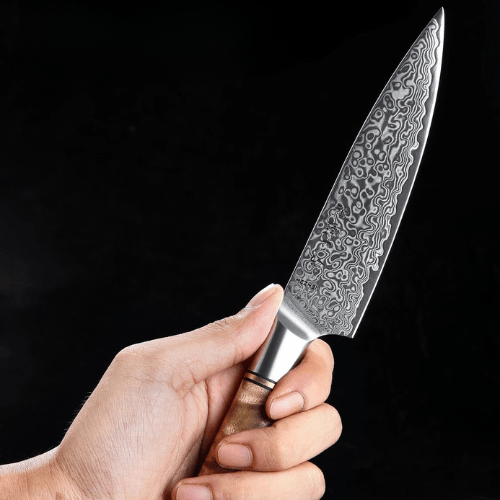 couteau japonais damas tenu dans une main