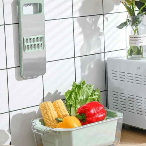 mandoline cuisine avec des légumes dans le bac et la grille suspendue
