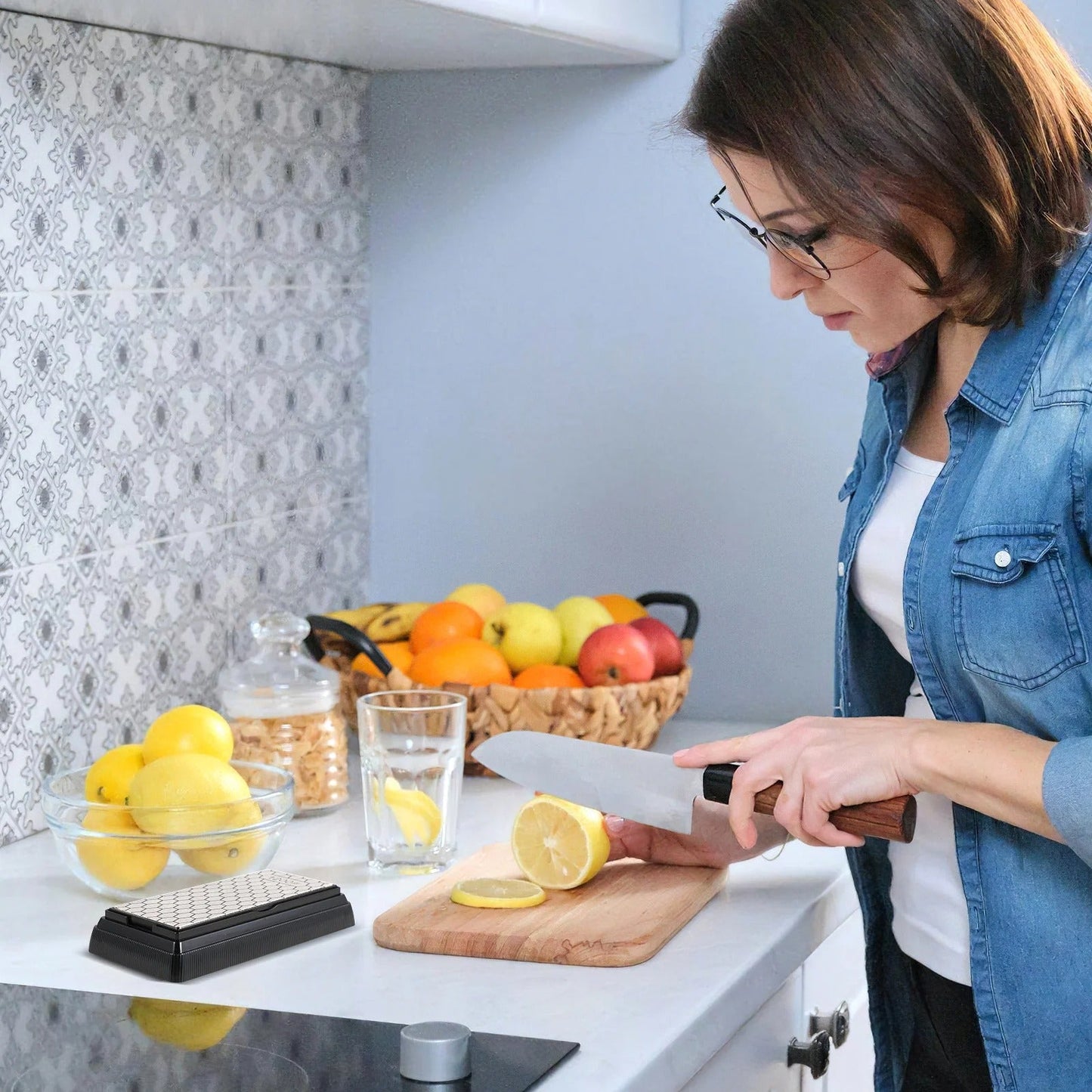 pierre a aiguiser femme coupant un citron avec la pierre à côté d'elle