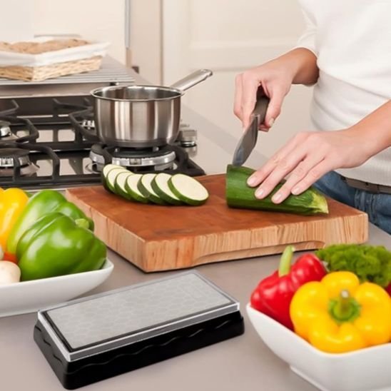 pierre a aiguiser femme coupant une courgette sur une planche a découper
