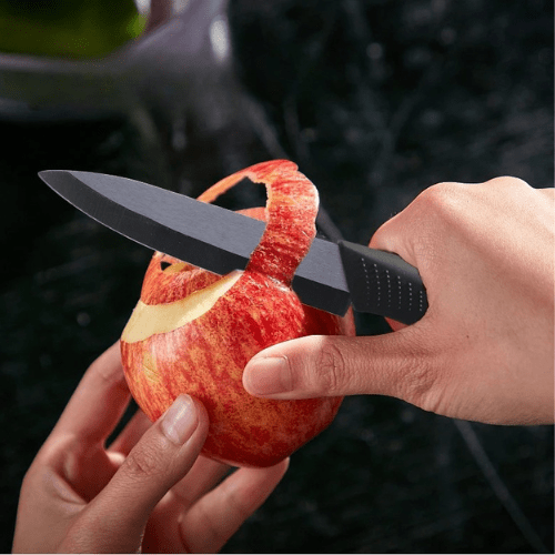 couteau ceramiqueépluchage d'un pomme rouge