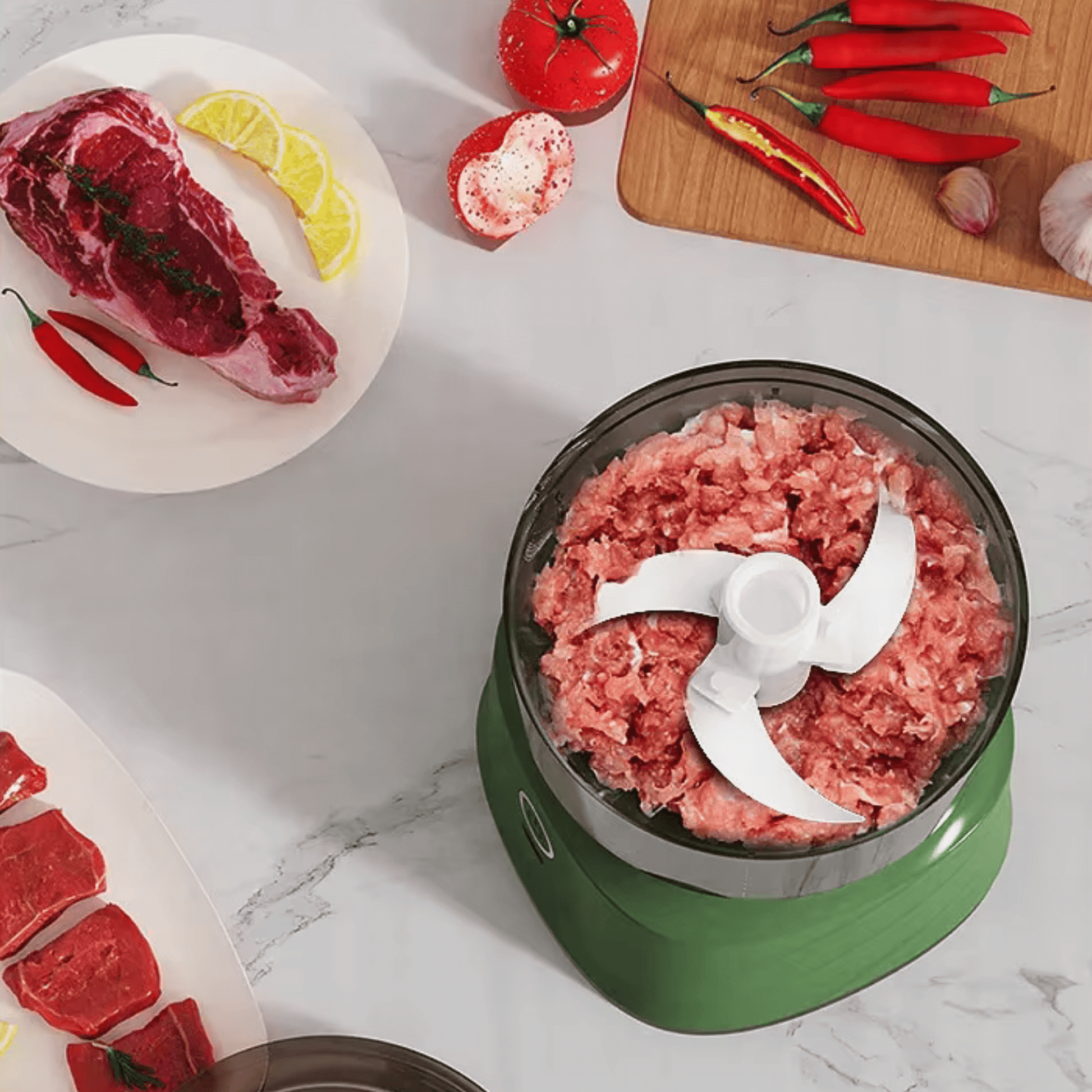 hachoir électrique avec viande moulinée et aliments autour