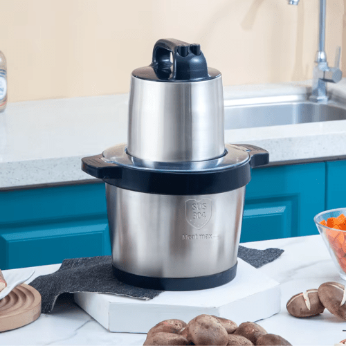 hachoir électrique sur une table avec des aliments autour