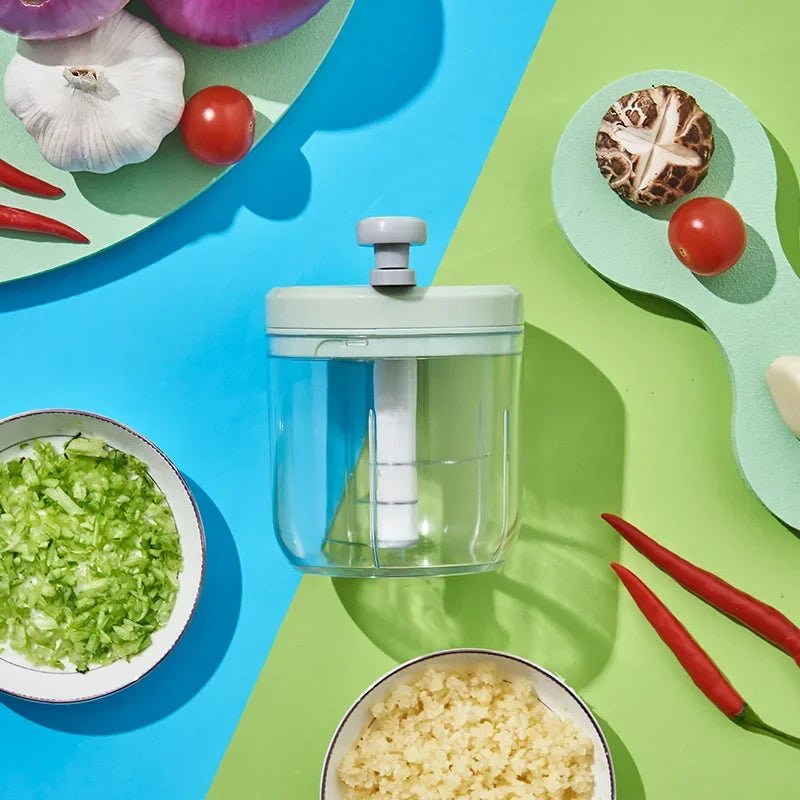 hachoir vu de haut sur fond bleu et vert avec des aliments autour