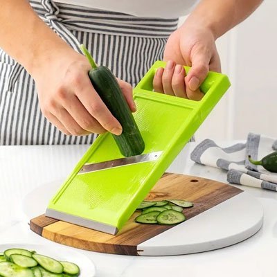 mandoline cuisine tranchage de concombre sur une planche