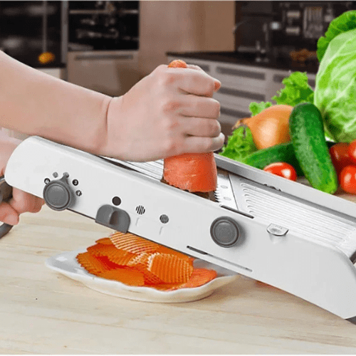 personne coupant une carotte avec mandoline cuisine